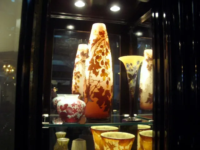 Vases en verre anciens décorés de fleurs par gallé dans une vitrine
