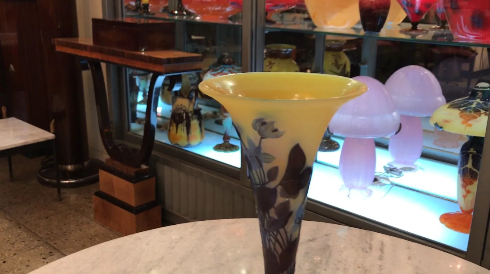 Verre signé Gallé avec décoration en jaune et violet dans un cadre d'antiquités.