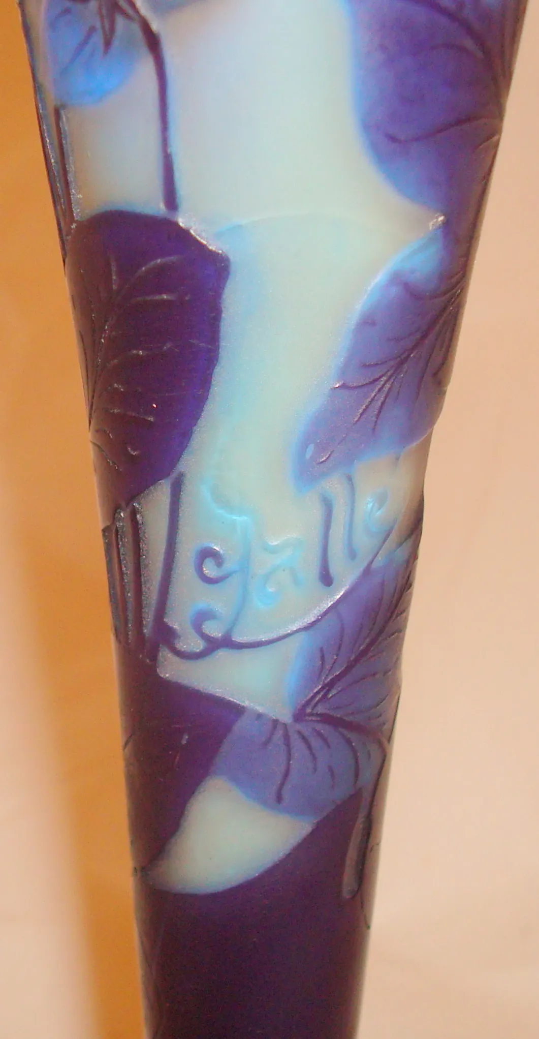 Verre antique signé Gallé avec décorations de feuilles et fleurs, couleurs bleu et violet.