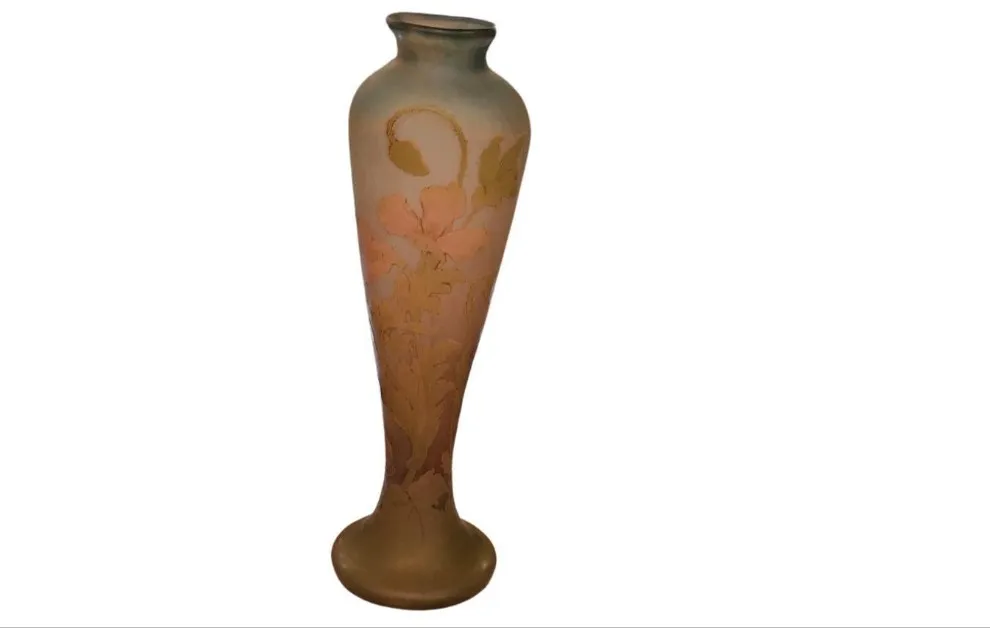 Botella antigua de vidrio con decoración floral y firma.