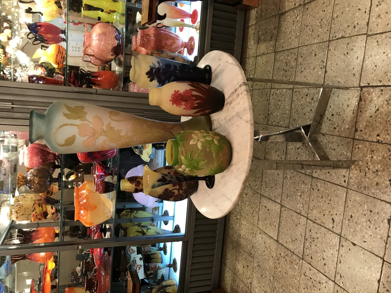 Verre signé Gallé sur table en marbre avec vases colorés