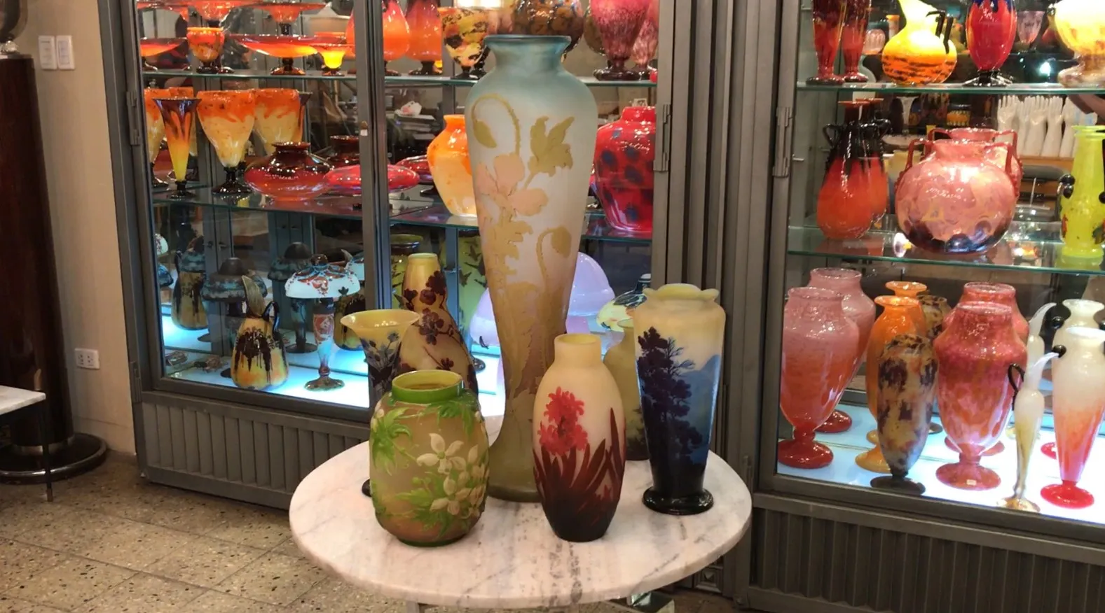 antik signiertes Glas Gallé zwischen bunten Antiquitäten ausgestellt