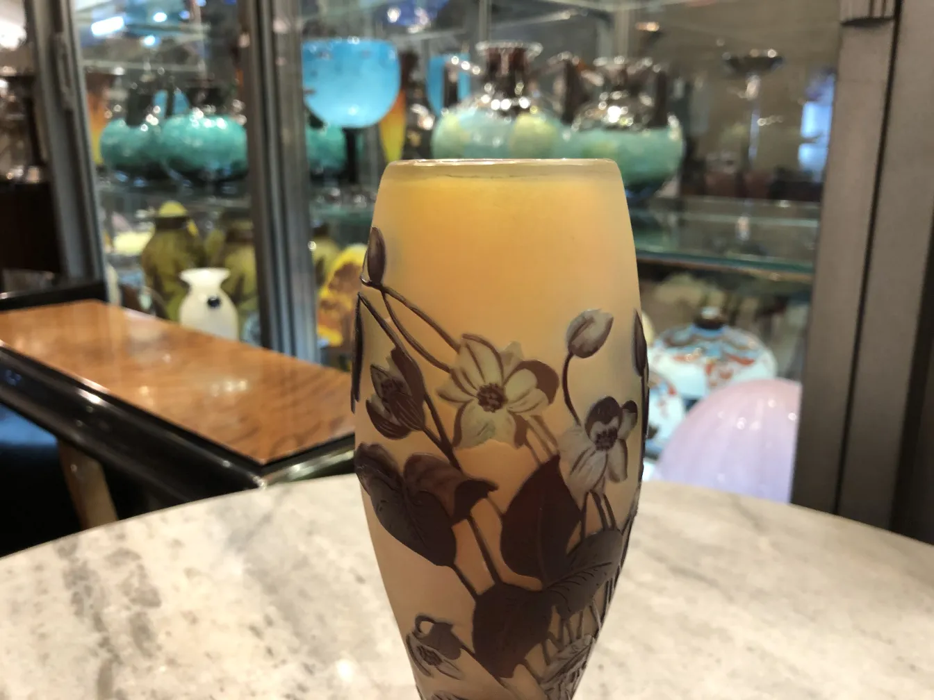 ग्लास पर हस्ताक्षरित Gallé, फूलों के डिज़ाइन और गर्म रंग के साथ, पुरानी सेटिंग में।