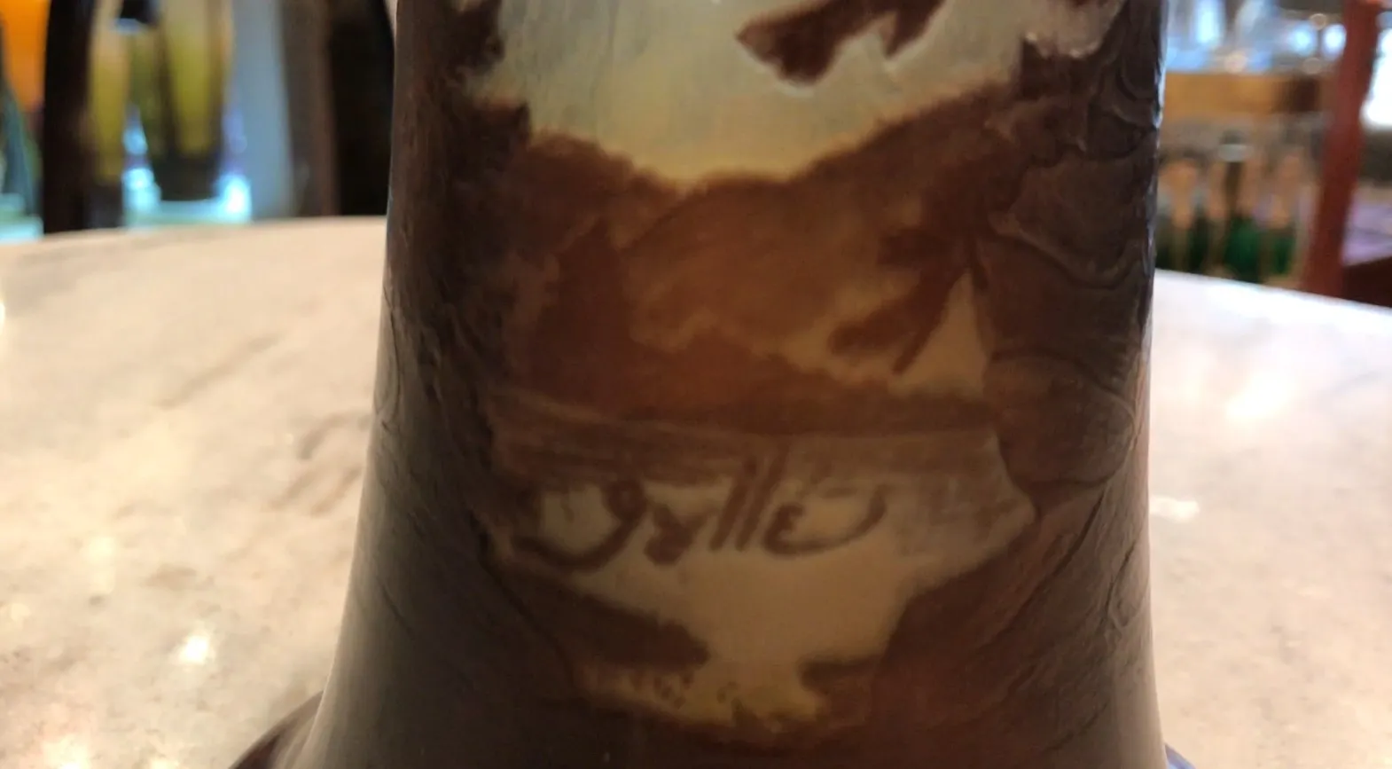 Verre signé Gallé, ancien avec détails décoratifs, arrière-plan naturel.