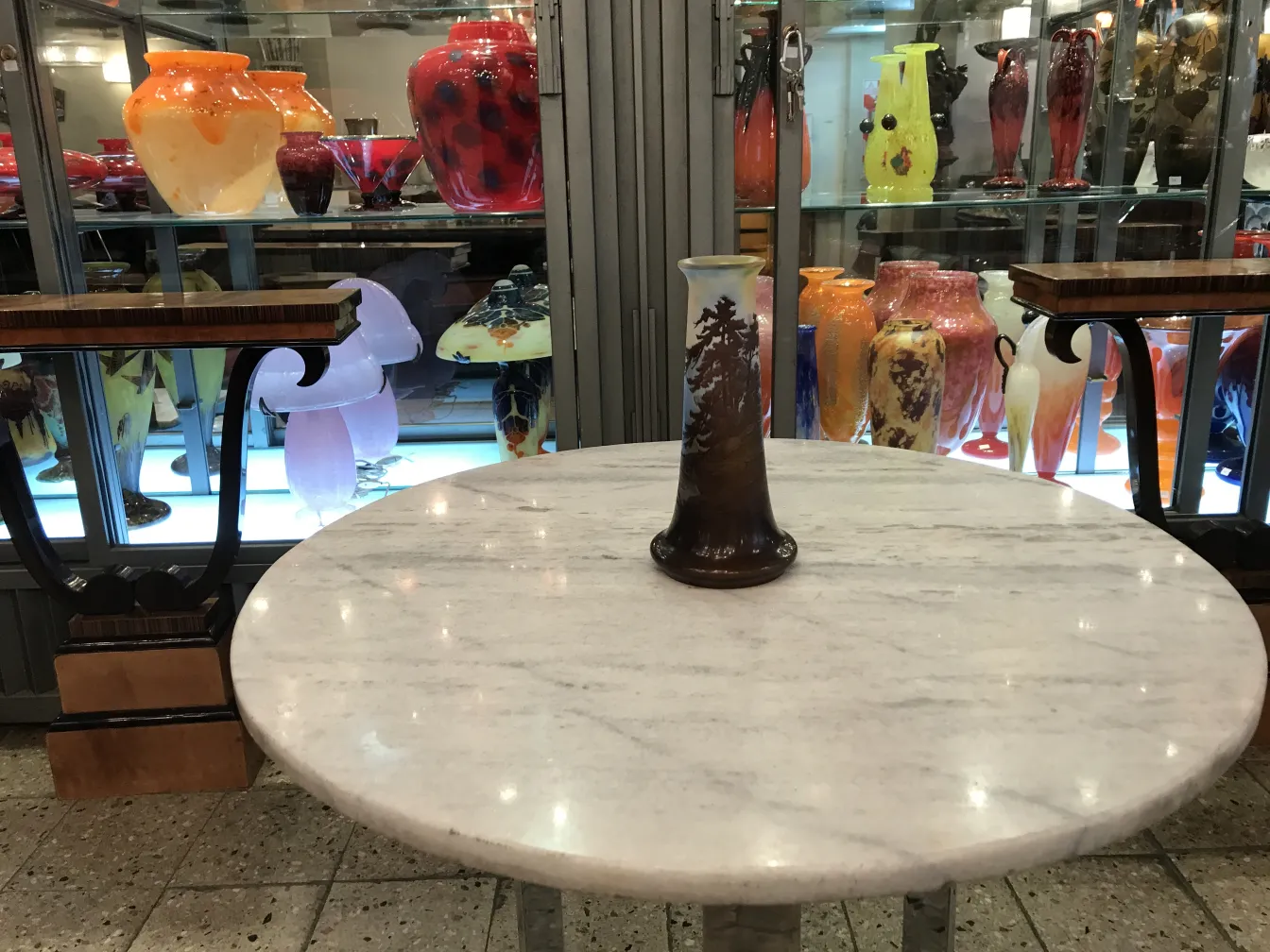 Antikes signiertes Glas Gallé auf einem Tisch mit bunten Vasen im Hintergrund