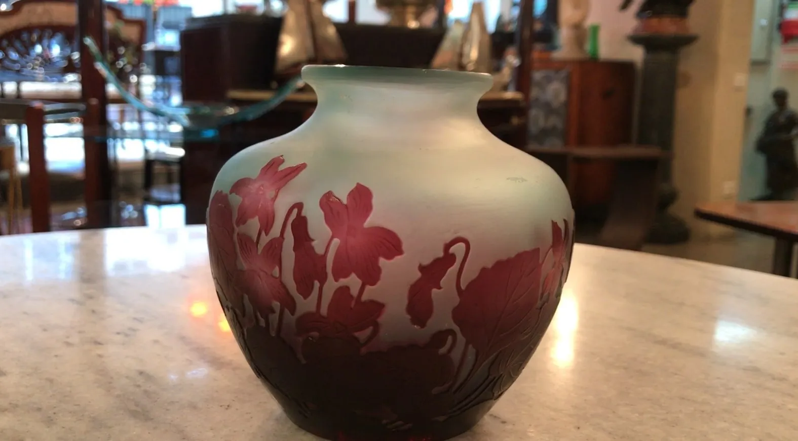 Antiquité verre signé Gallé avec motif floral dans un cadre chaleureux.