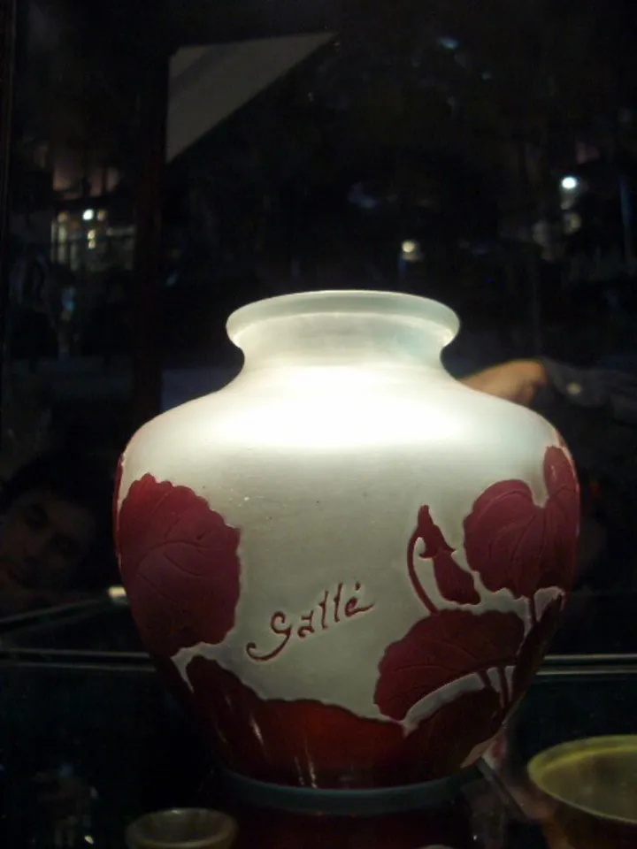 Jar antique en verre signé Galle, avec des décorations de feuilles rouges.