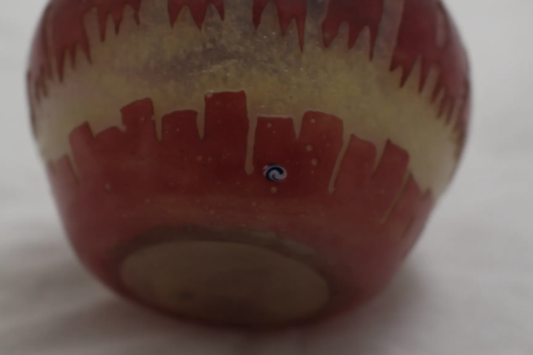 Vidrio firmado con diseño de caramelo y bandera francesa en colores rojo y amarillo sobre fondo blanco.