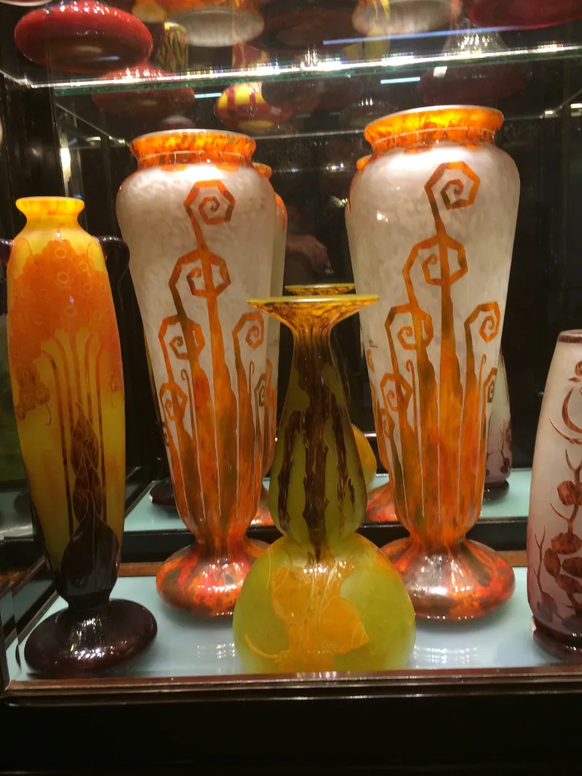 Antique signed glass vases with vibrant colors and decorative shapes in the display