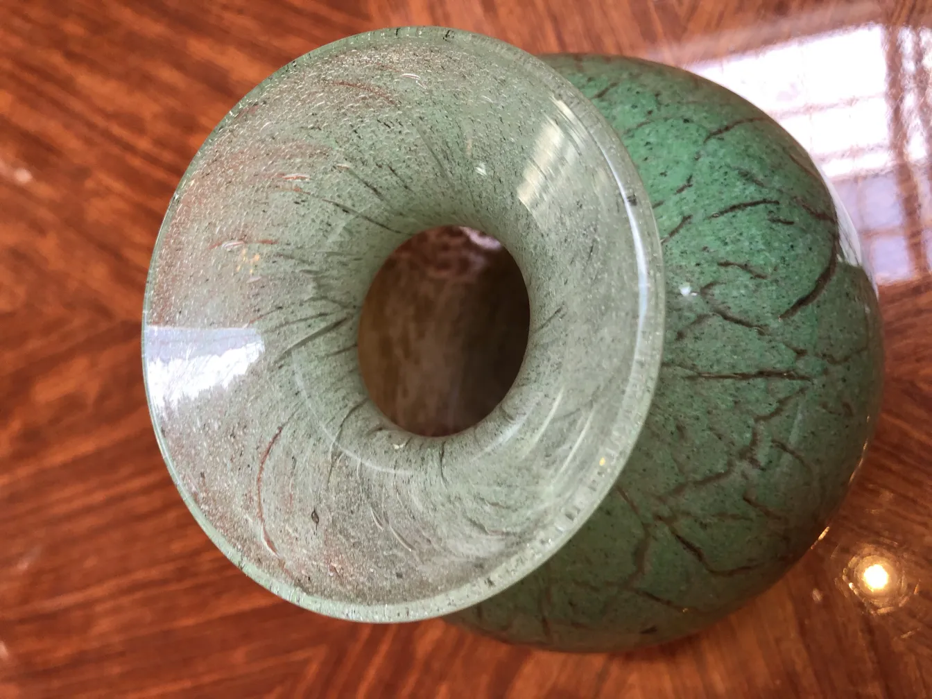 Obenansicht eines signierten grünen Glases mit Details.