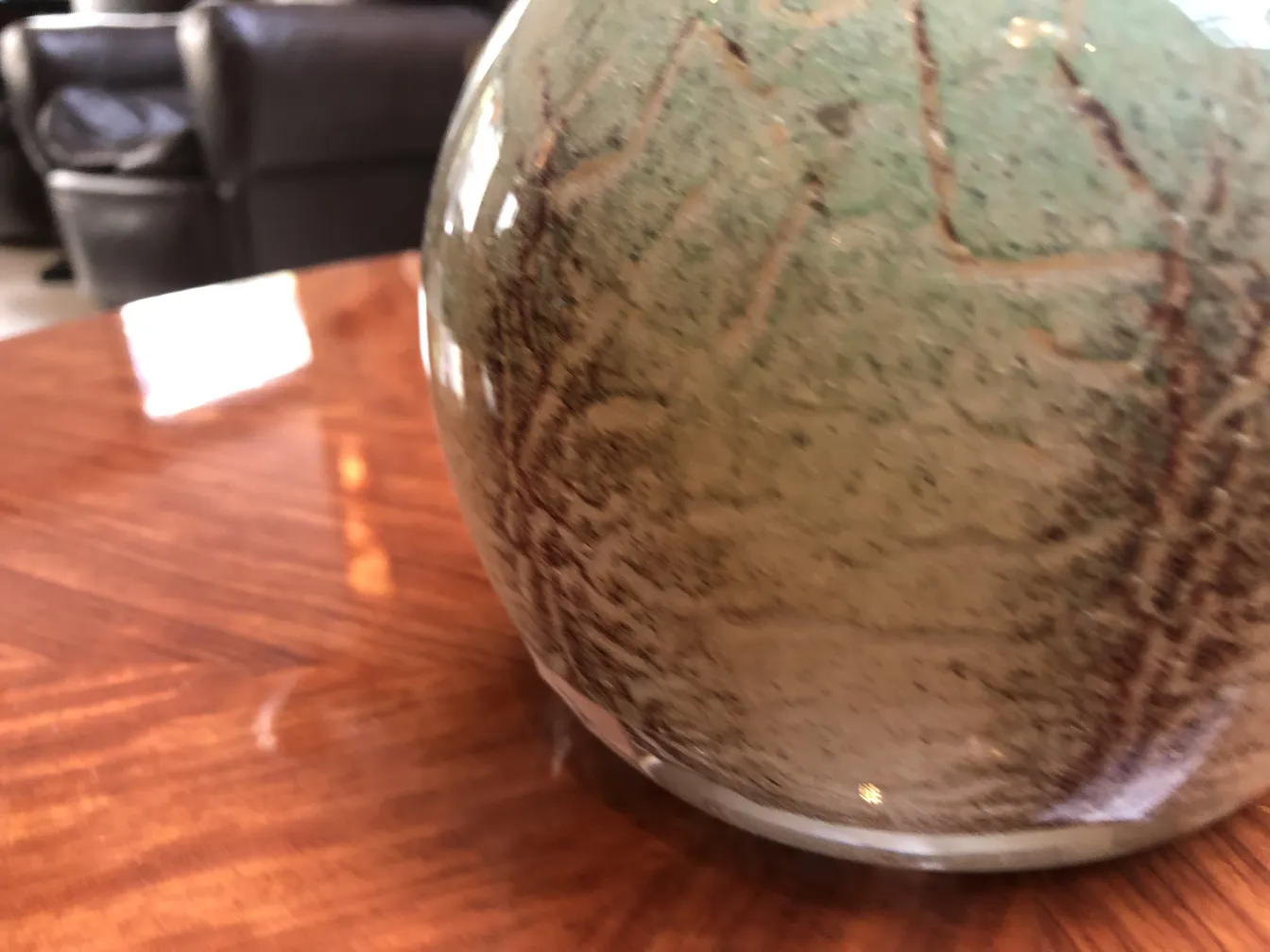 Signed glass with organic and textured design, rustic setting.