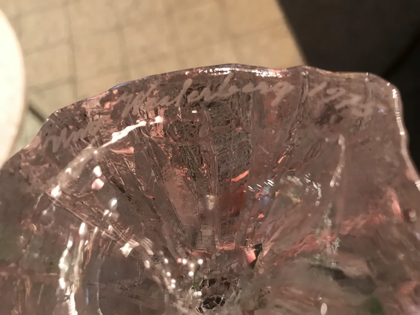 Vidro assinado antigo com detalhes decorativos em várias tonalidades.