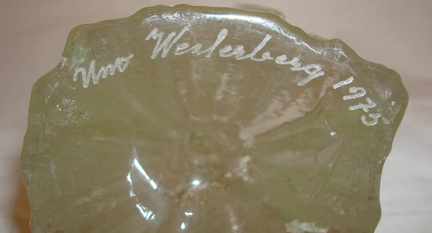 Signiertes Glas mit dekorativen Inschriften, vintage, in einem antiken Umfeld.