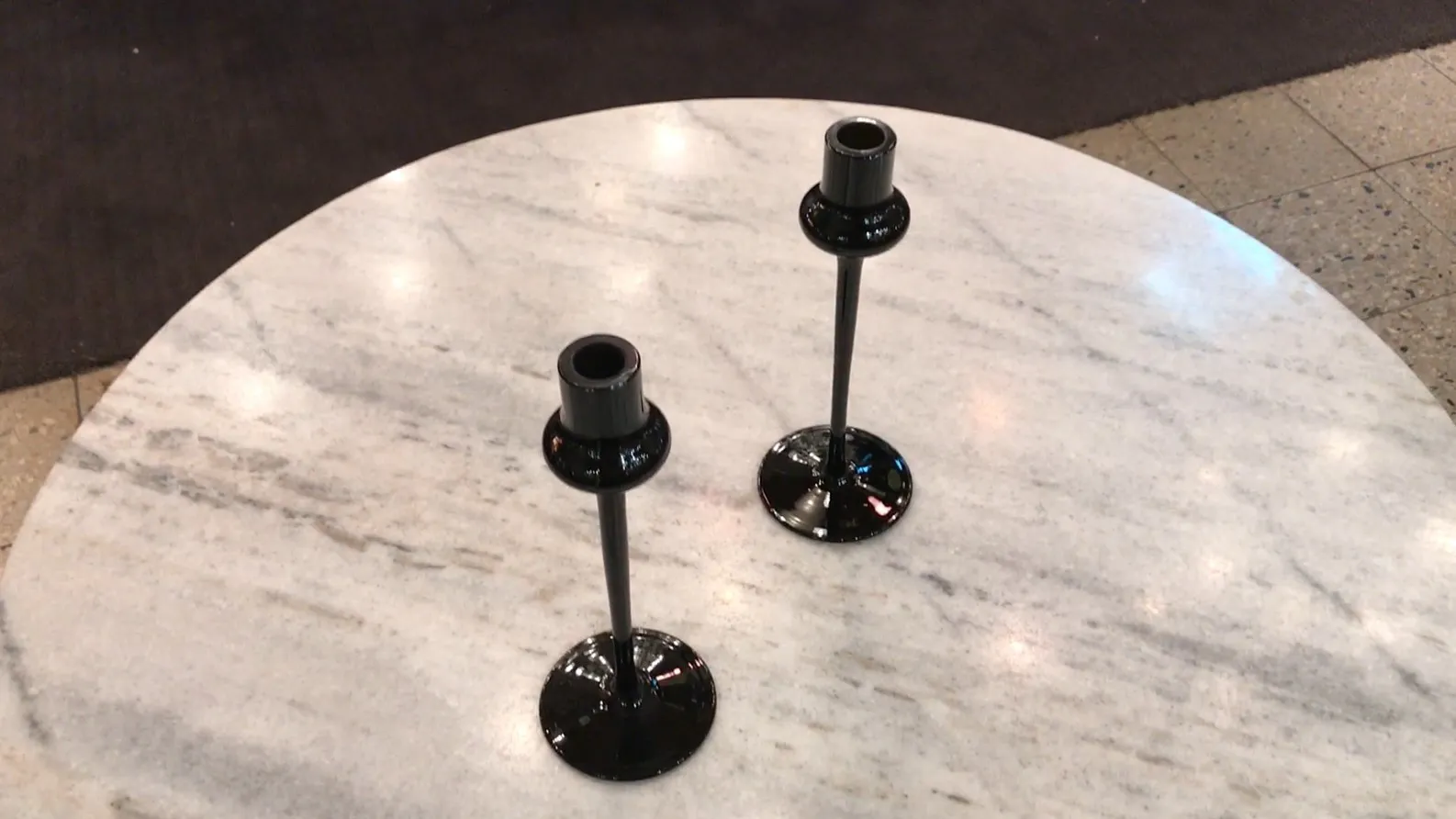 suportes de vela pretos sobre mesa de mármore