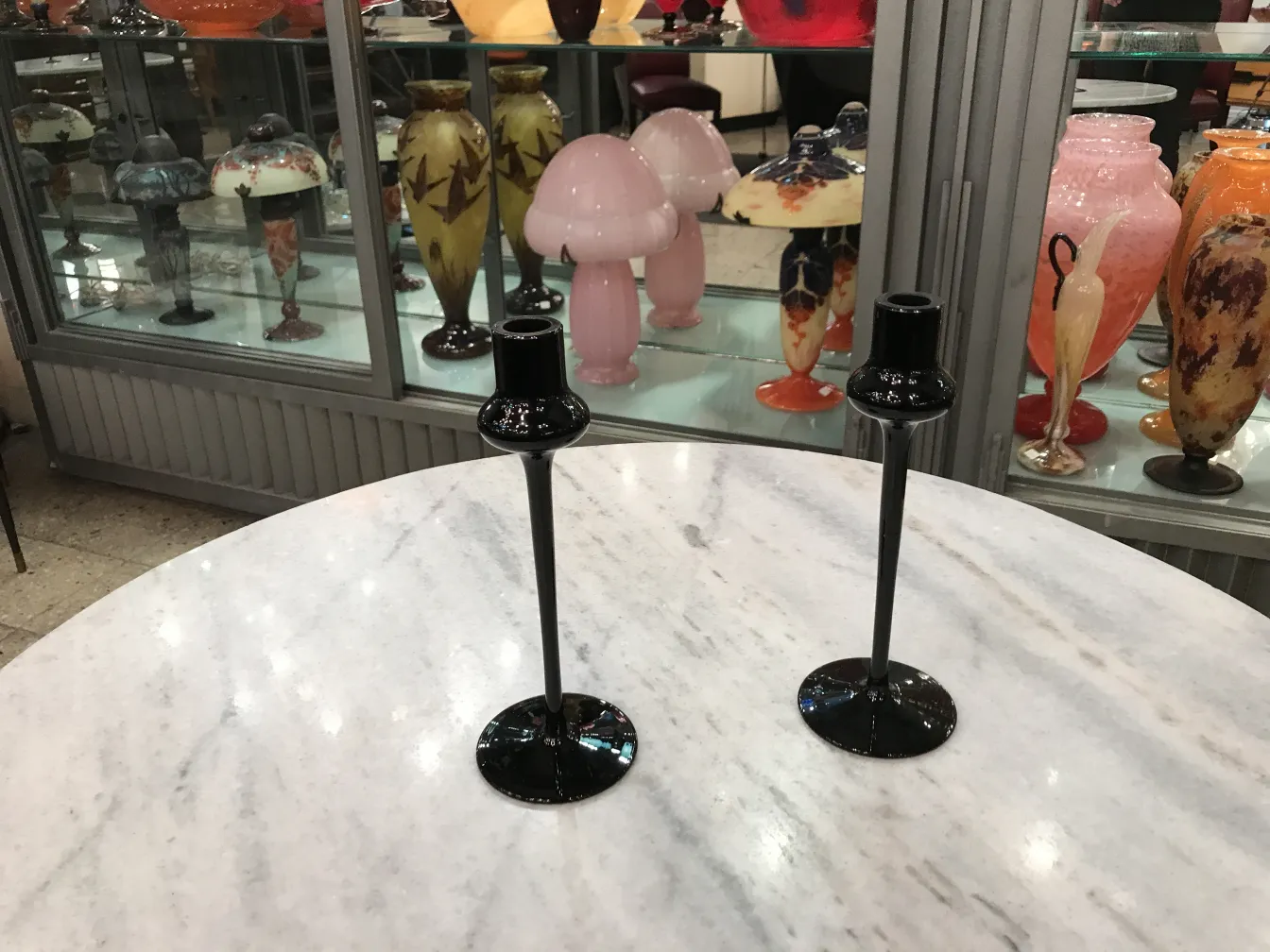 شمعدانات زجاجية سوداء مع خلفية عرض قديم