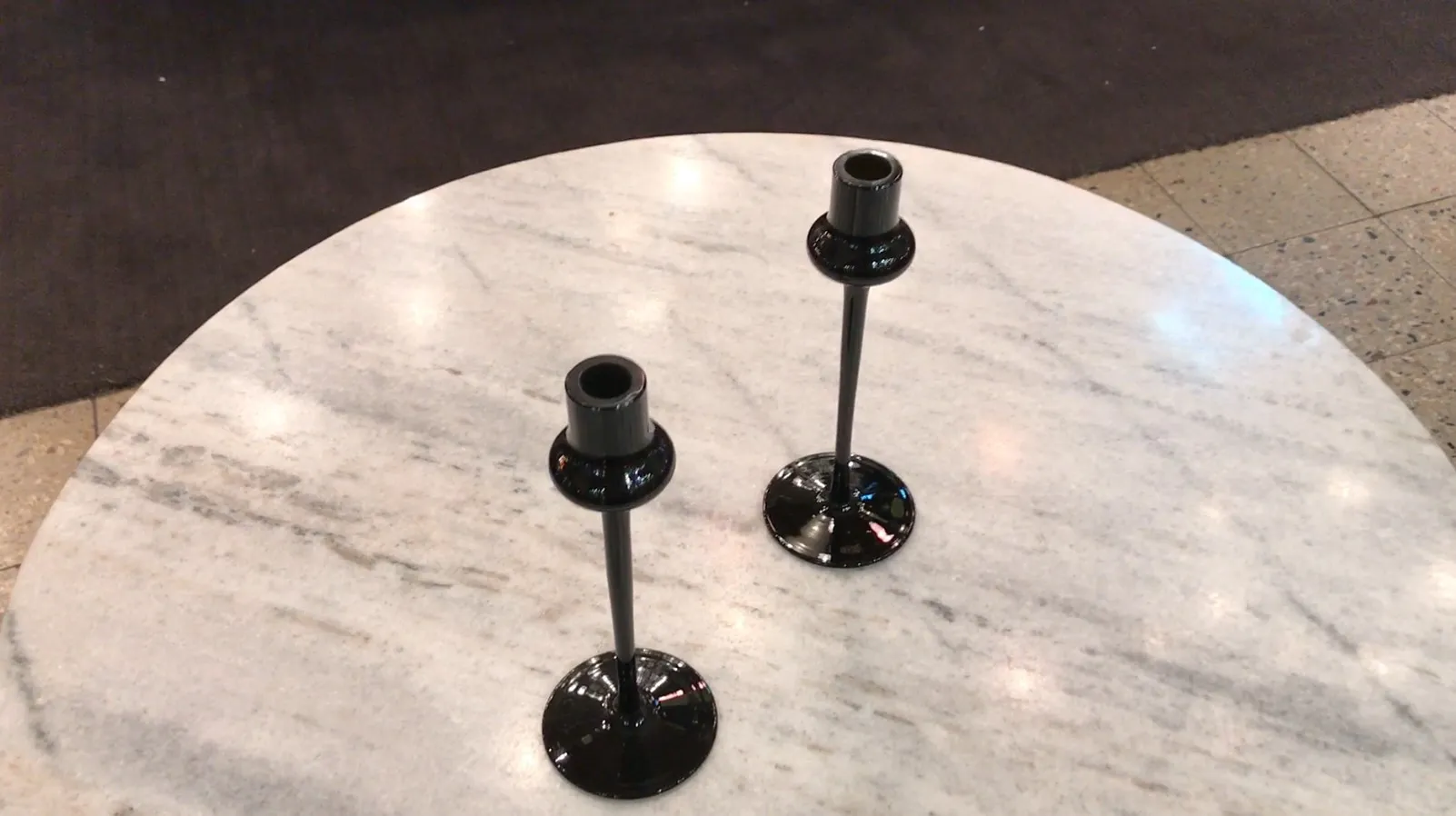 dos candelabros de vidrio firmado sobre mesa de mármol