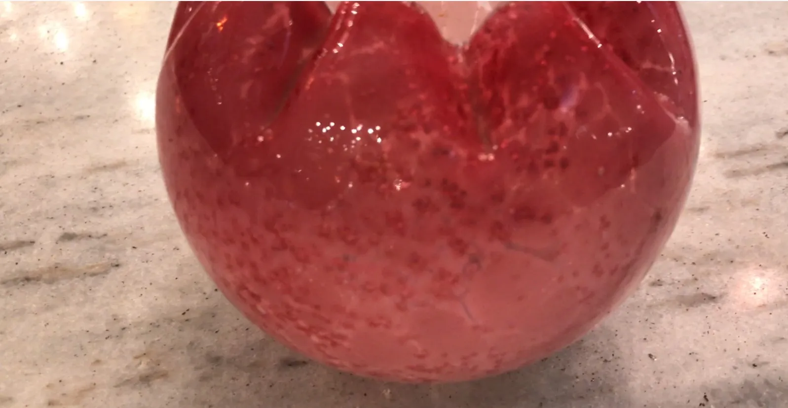 Verre signé ancien de couleur rouge avec des détails brillants.