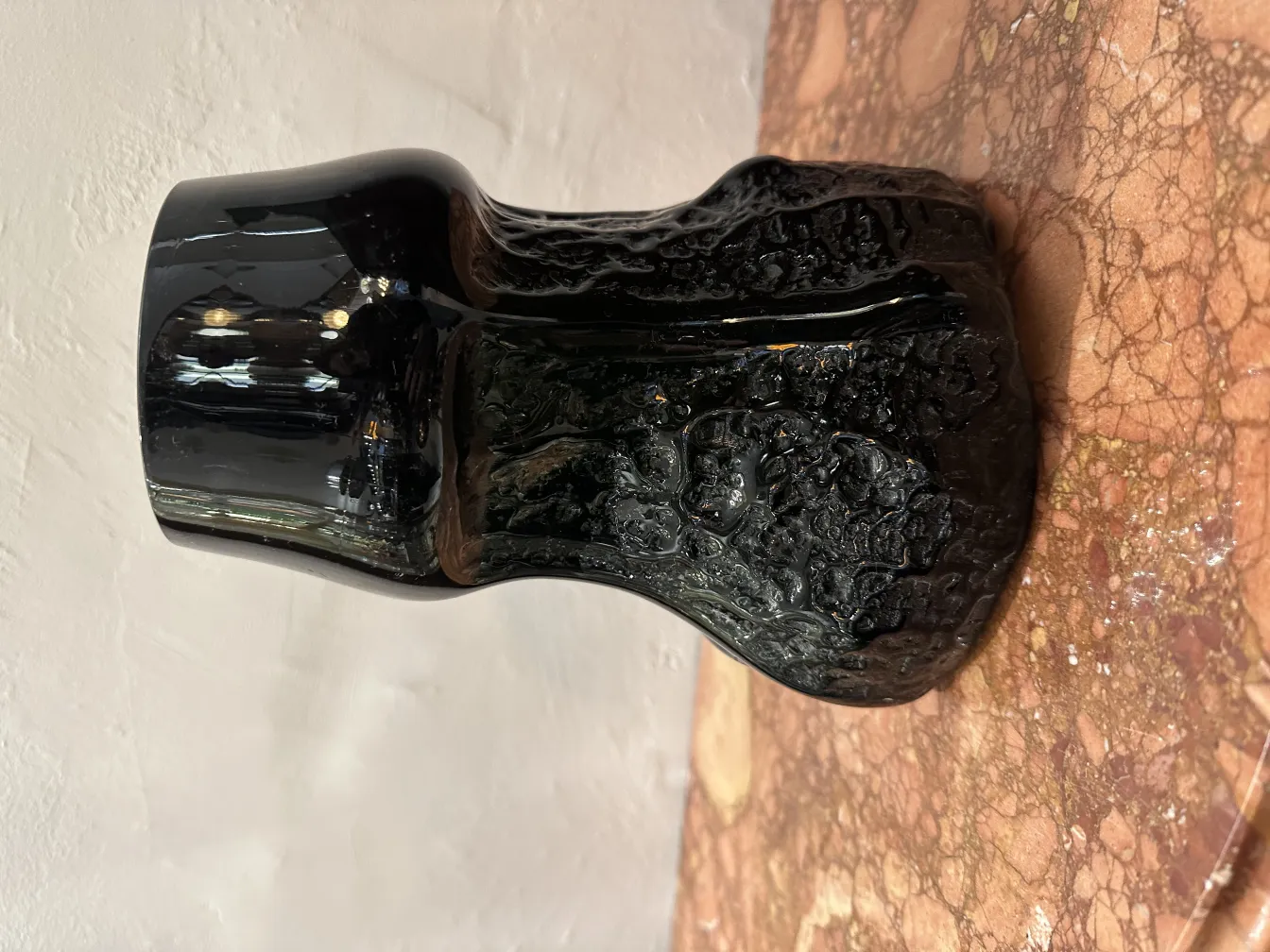 Элегантное стекло с подписью и уникальной текстурой на мраморном фоне.