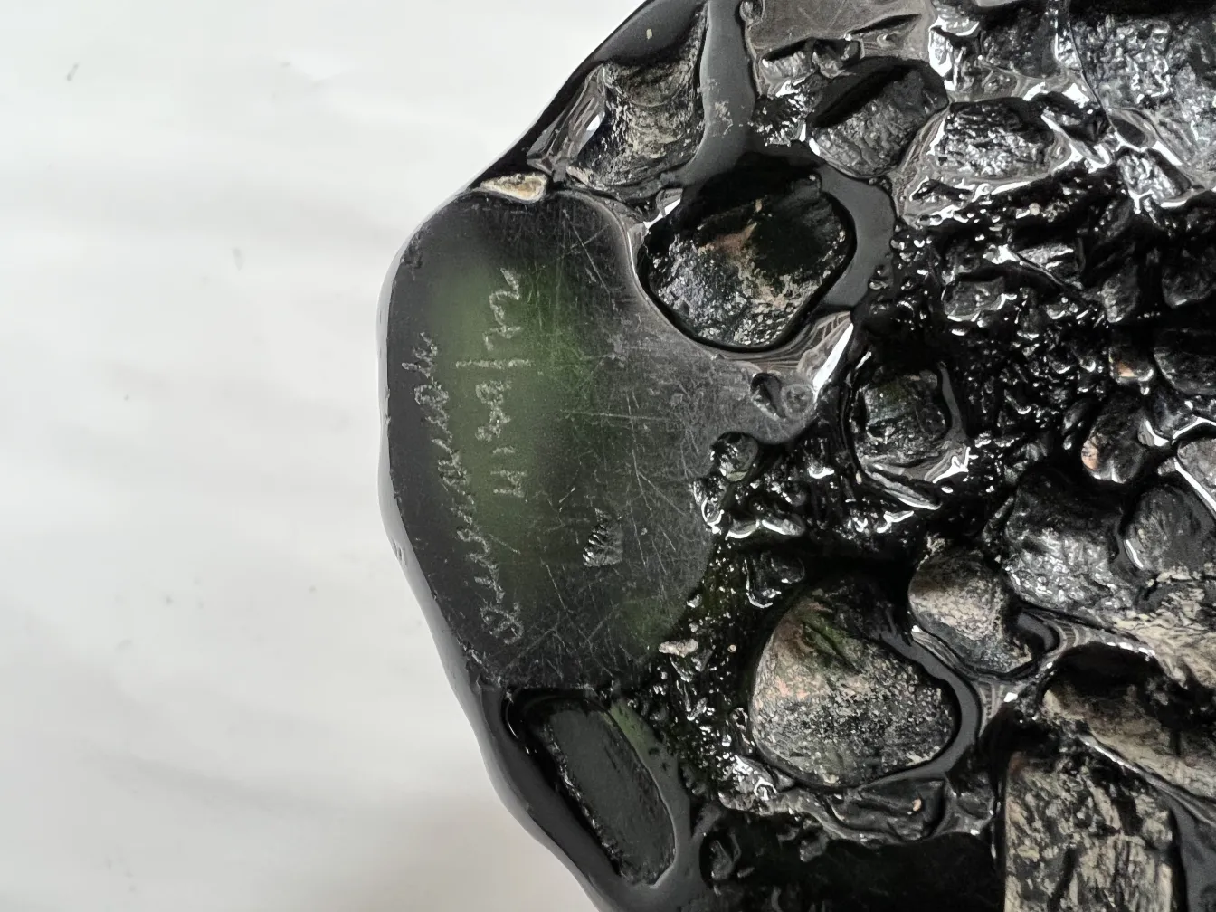 Verre ancien avec une signature visible sur la surface sombre.