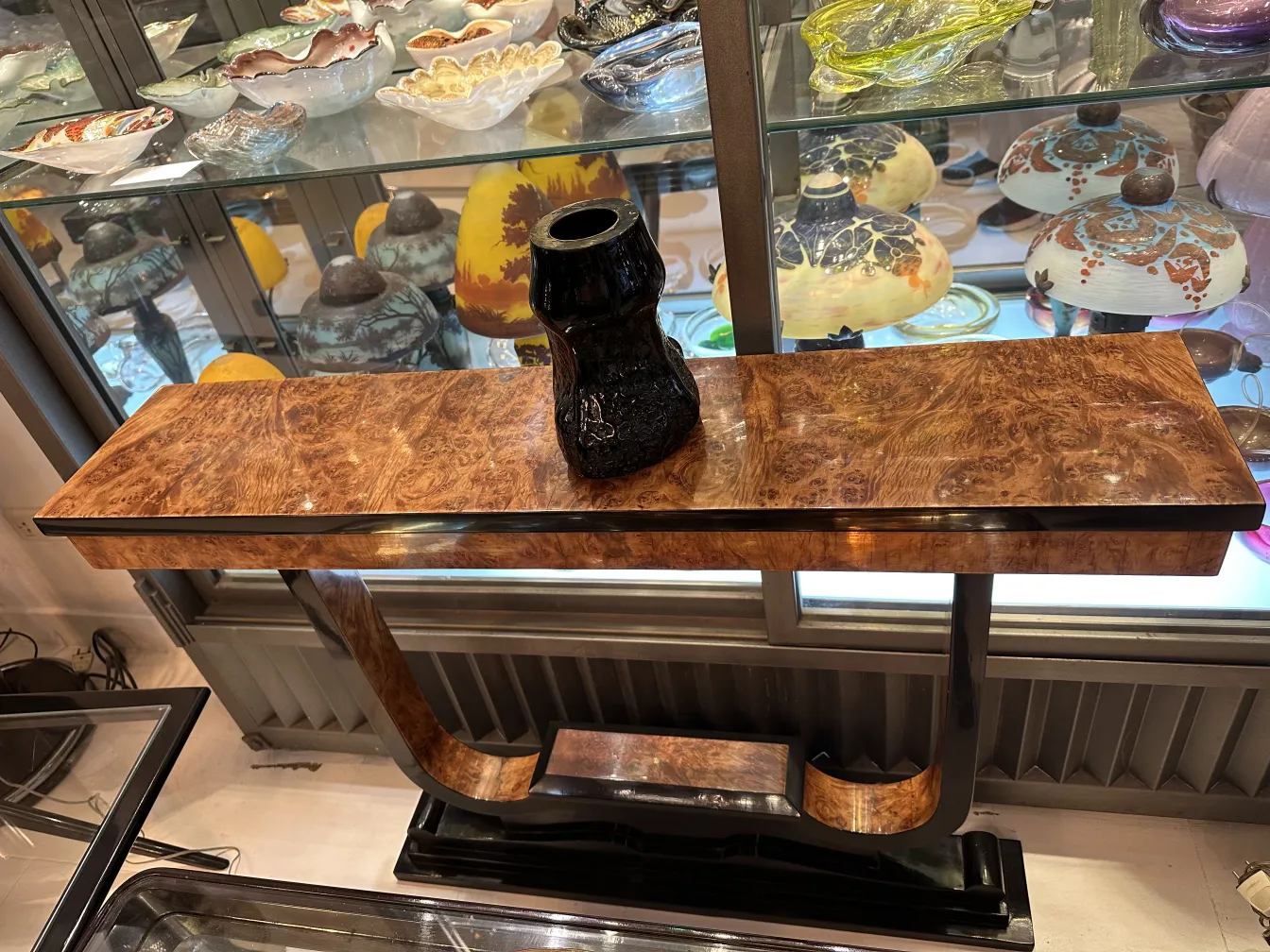 Vetro firmato antico con tonalità calde esposto in un ambiente elegante.