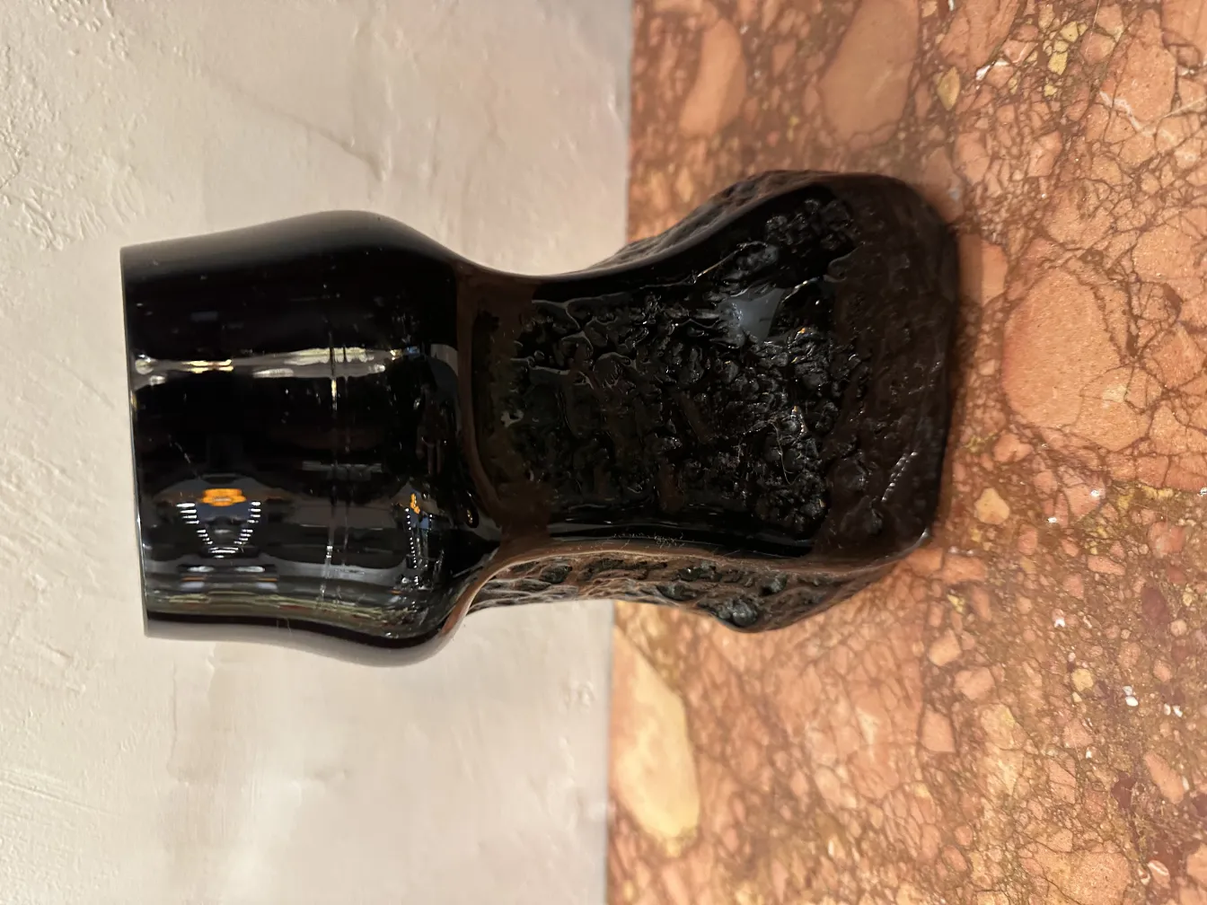 Vaso de vidro preto com assinatura antiga, decoração em relevo.