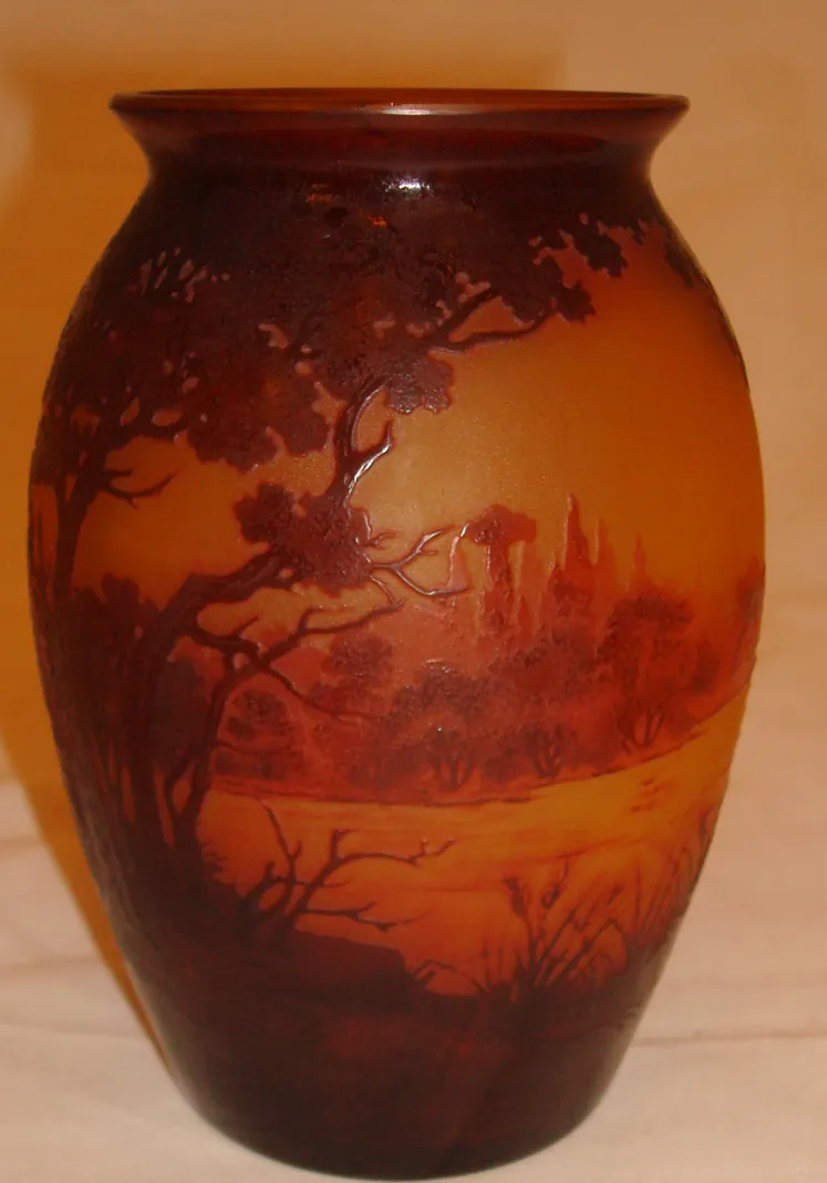 Vidrio firmado D'Argental con paisaje decorativo en tonos cálidos.