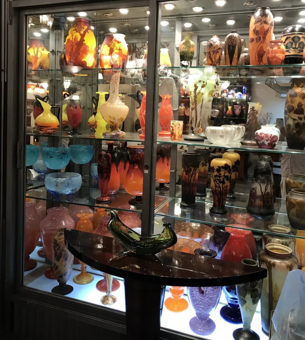 Ausstellung von Antiquitäten einschließlich signiertem Glas D'Argental, Vielfalt an Farben. Ideal für Sammlungen.