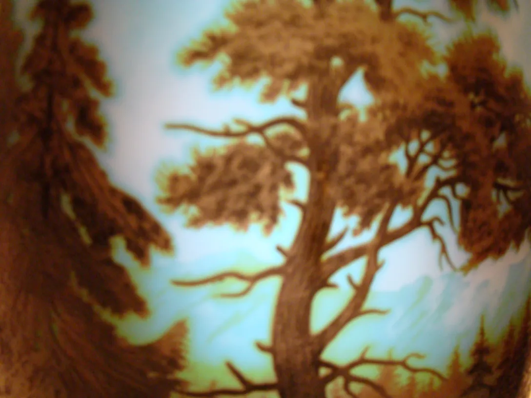 Detailed view of an antique signed glass D'Argental featuring trees in the design.