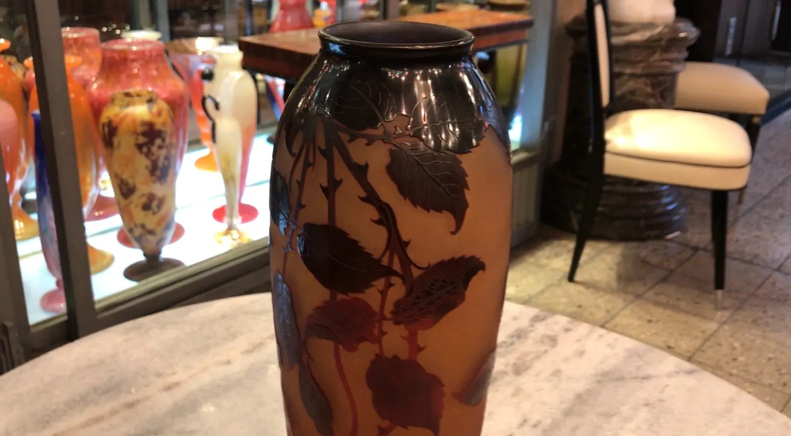 Vidro antigo assinado D'Argental com decoração floral, lindamente elaborado. Fundo com outros objetos de vidro coloridos.