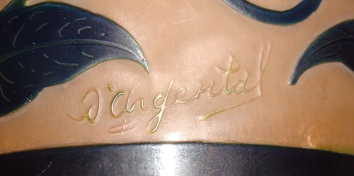 Signiertes Glas D'Argental mit Blattdesign auf buntem Hintergrund