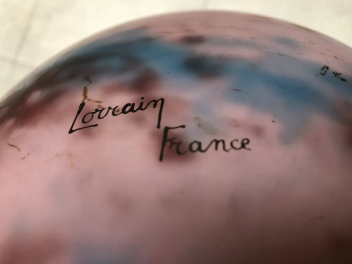 प्राचीन ग्लास पर हस्ताक्षरित लॉर्रेन, हल्के रंगों की पृष्ठभूमि।