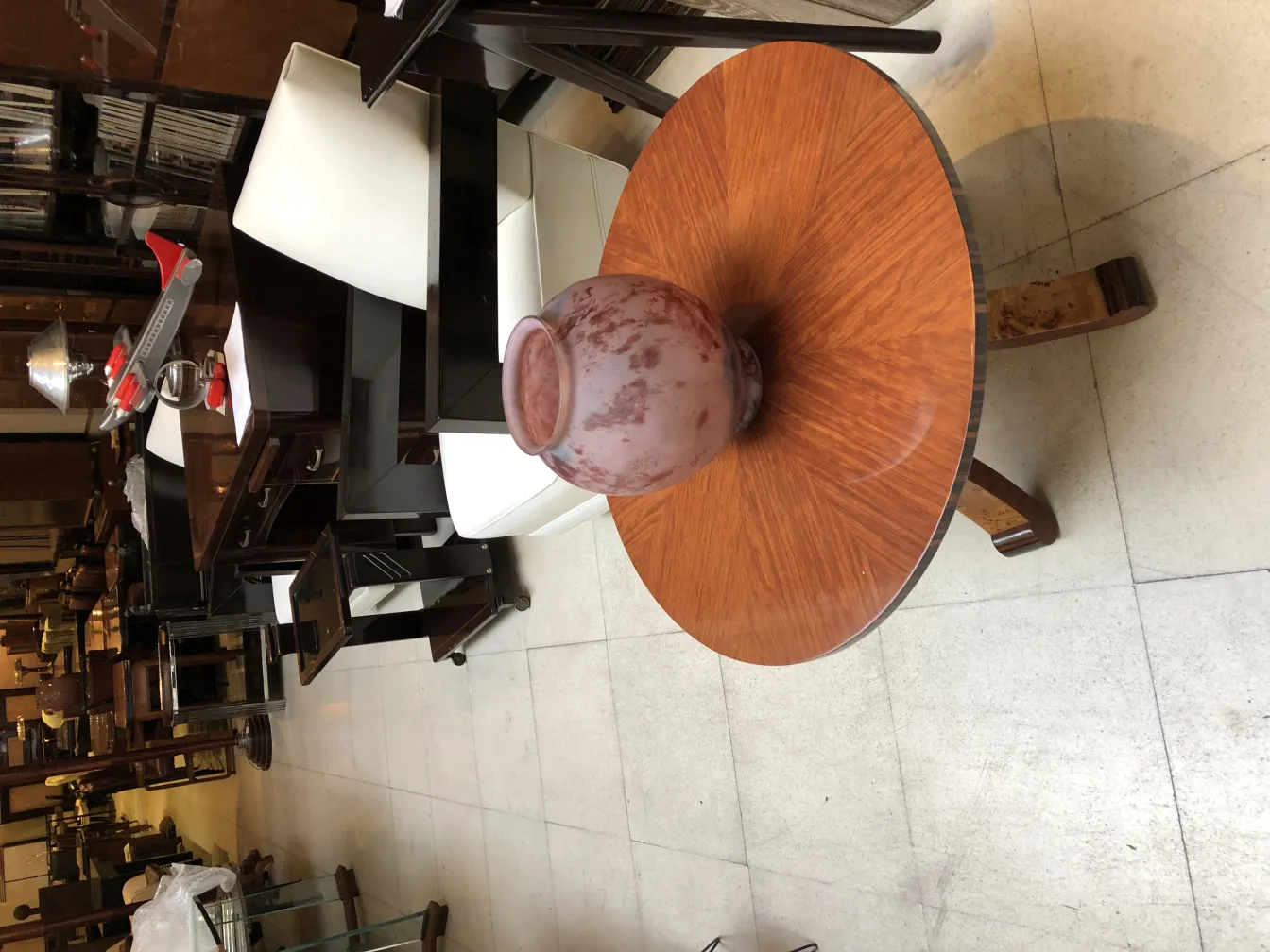 Vidro antigo assinado Lorrain em uma mesa de madeira em um ambiente vintage.