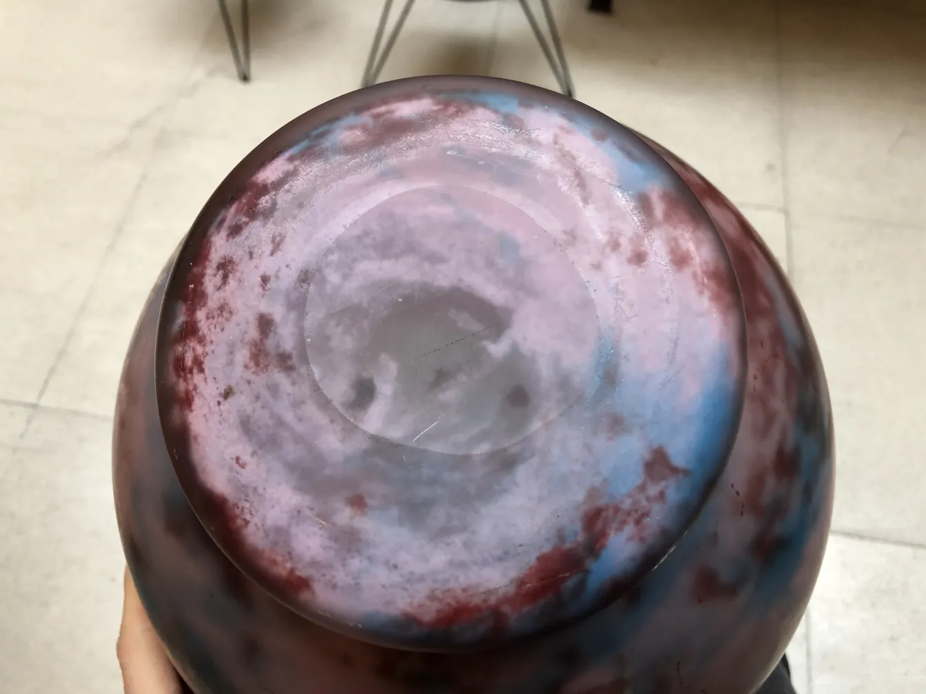 Visão superior de um vidro assinado Lorrain antigo em tons de roxo e azul.