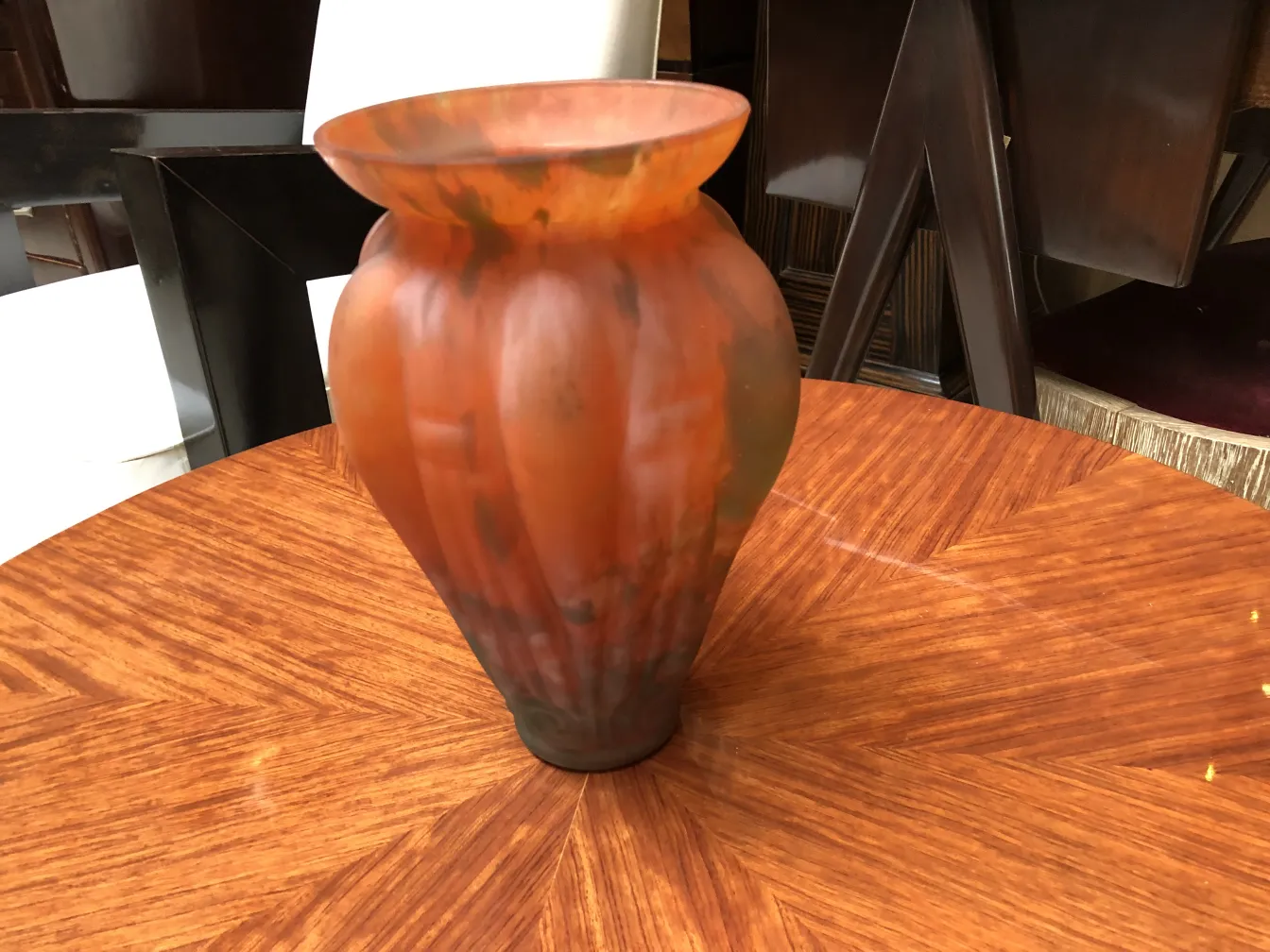 Um elegante vidro assinado de Lorrain sobre uma mesa de madeira.