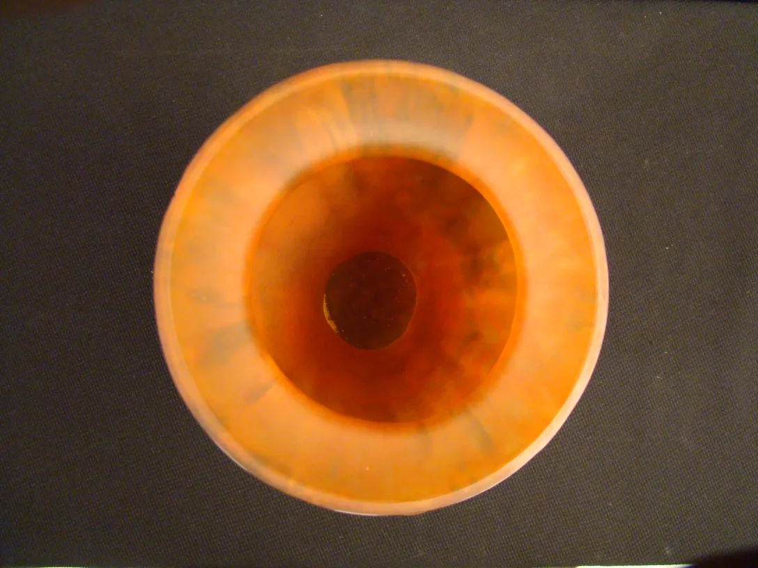 Vue de dessus d'un ancien verre signé Lorrain aux teintes orange.