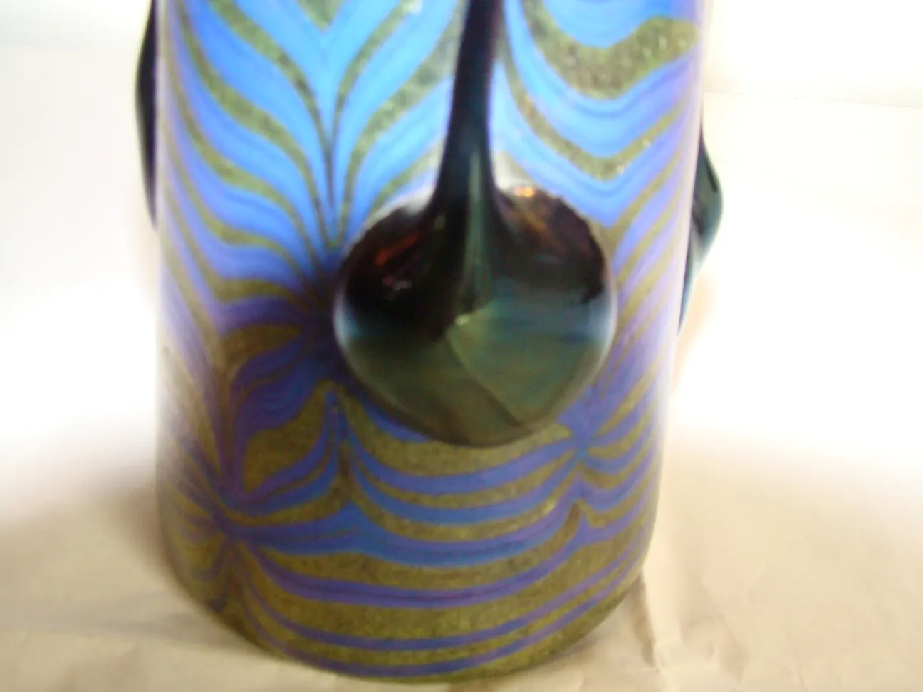 Signed Loetz glass featuring intricate blue and green patterns.