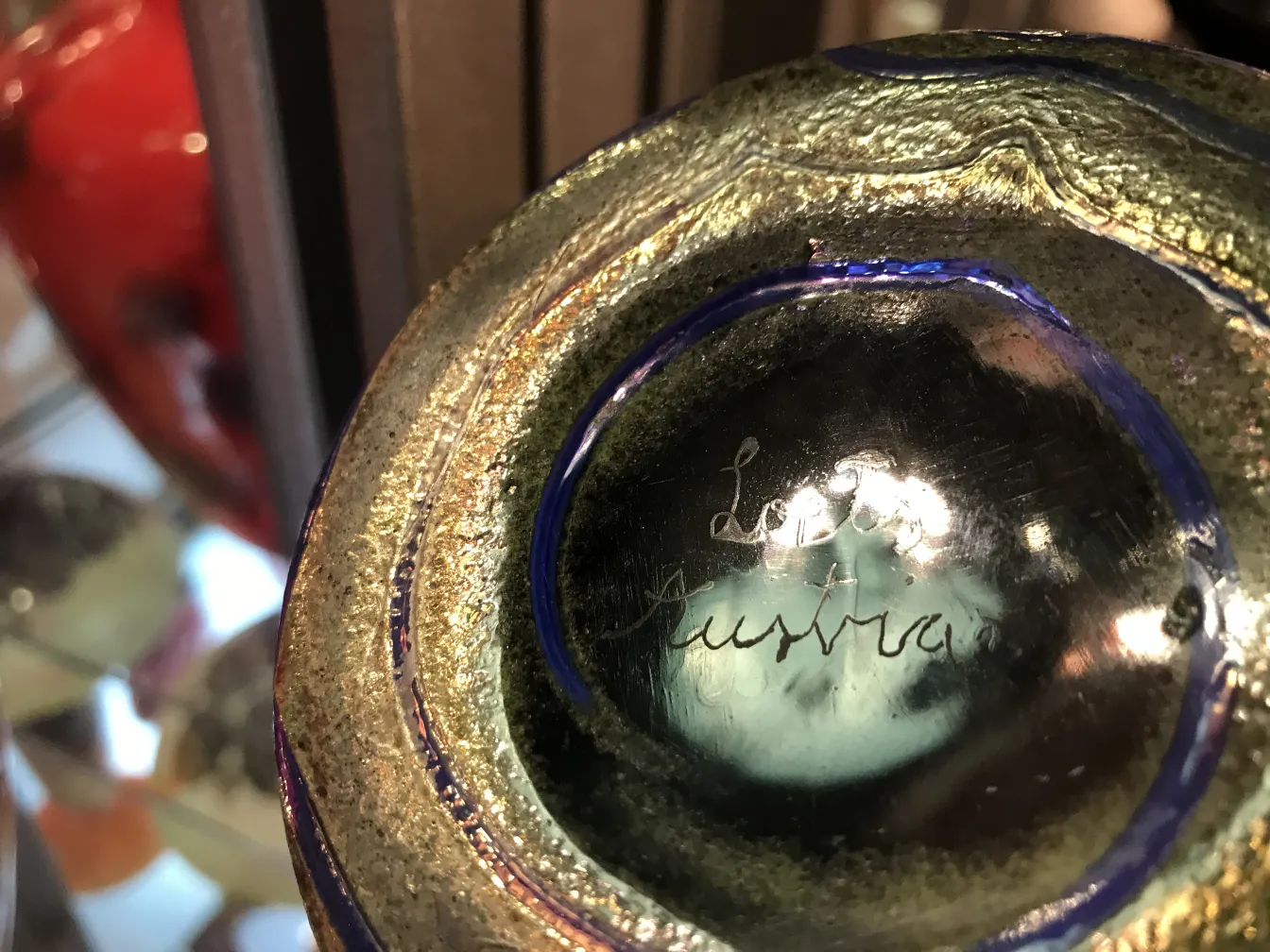 Detalhe de vidro antigo assinado por Loetz, brilhante e decorativo.