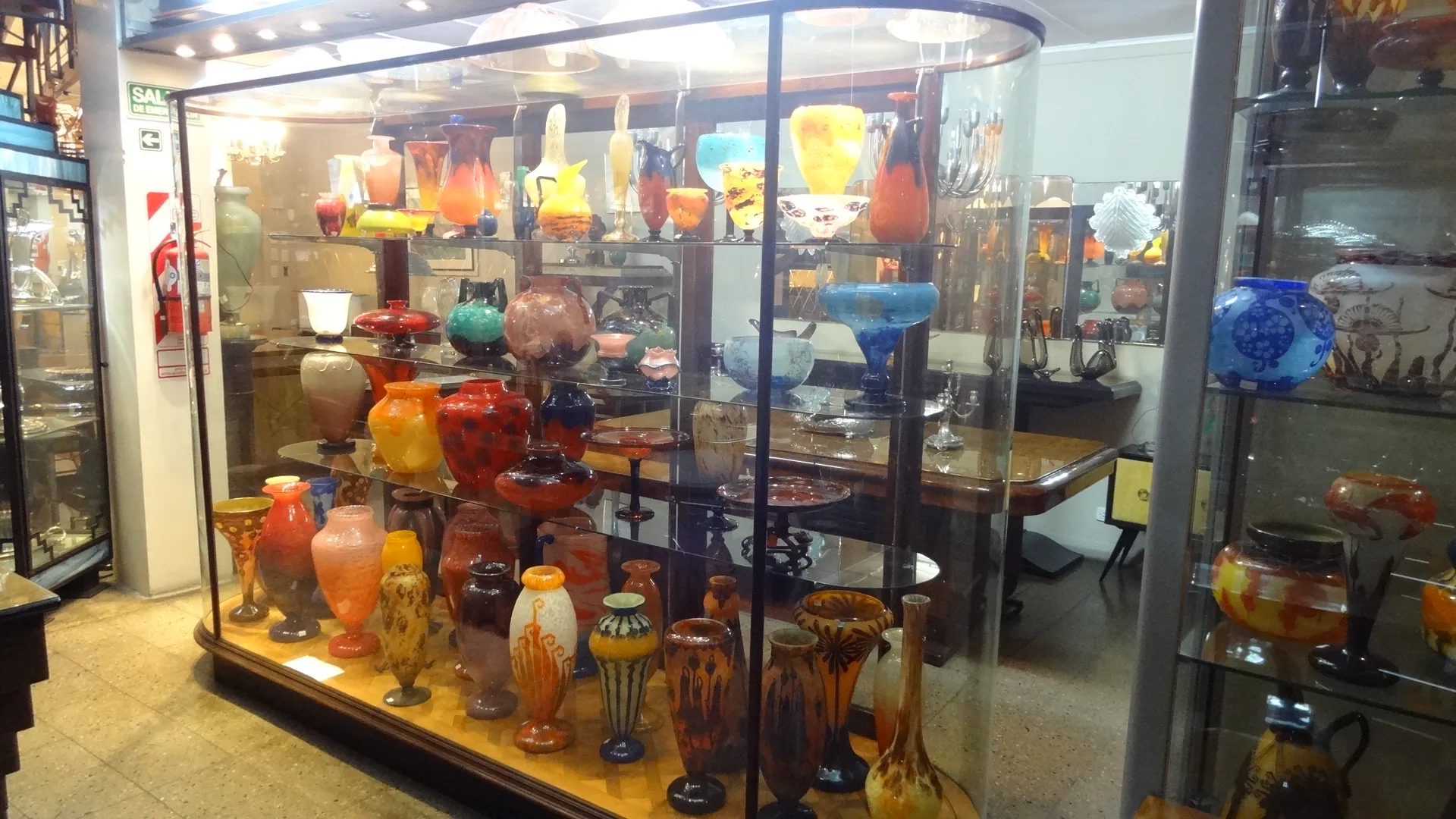 showcase with colorful antiques and signed glass Loetz