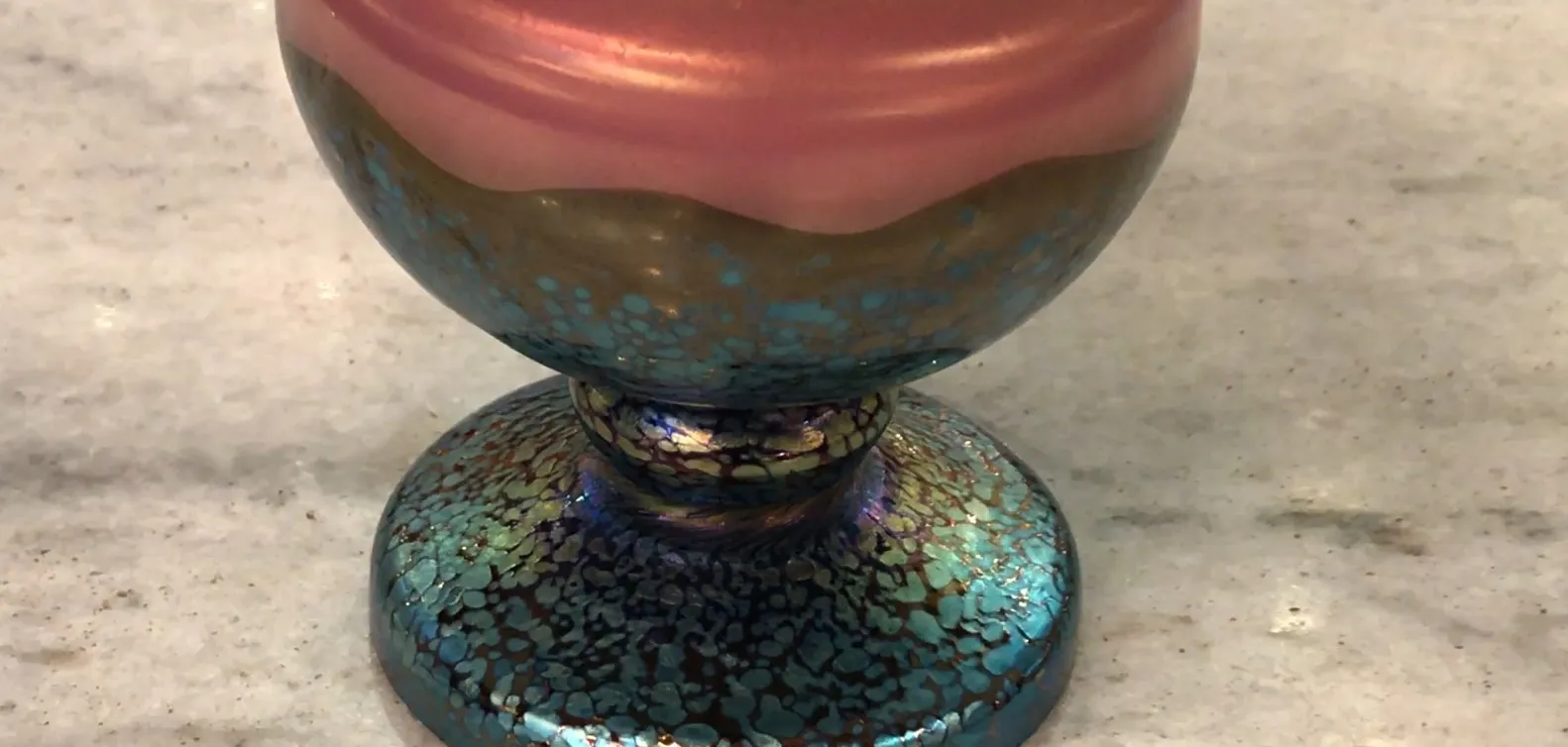 Vetro Loetz antico con design colorato e base decorativa.