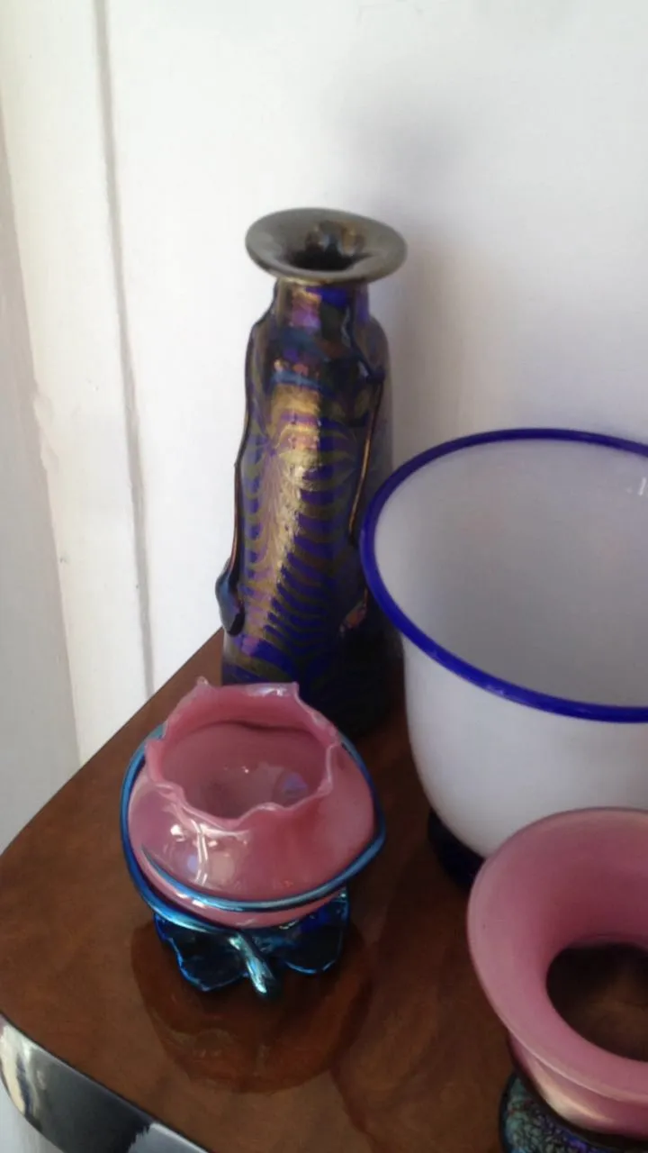 Verre antique signé de Loetz aux couleurs vives, décoré d'un design distinctif, accompagné d'autres objets décoratifs.