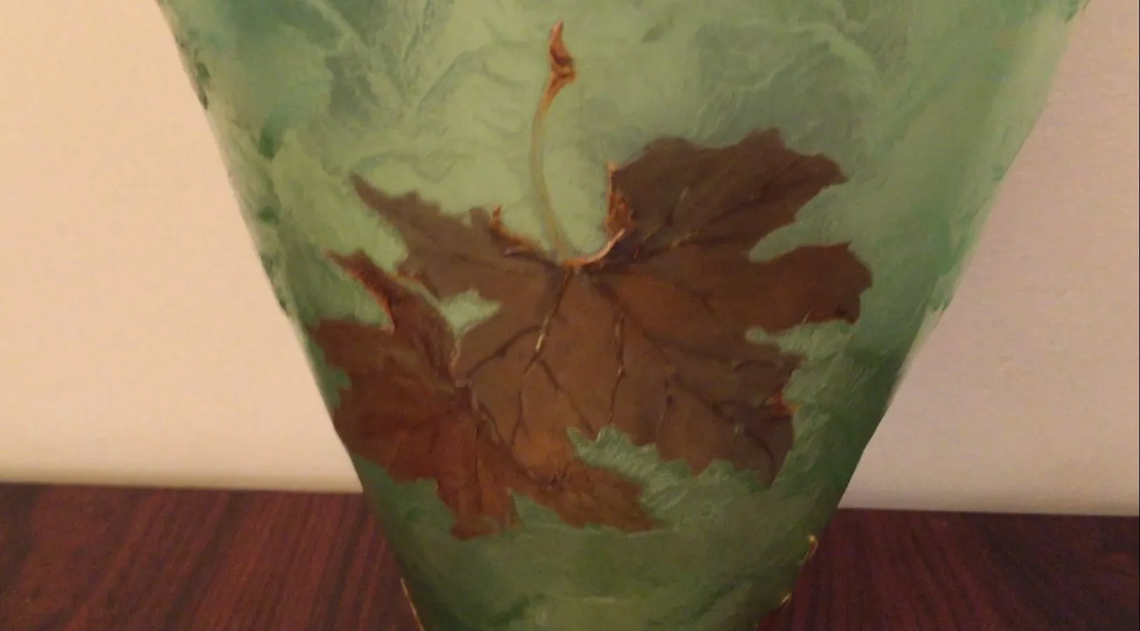 茶色と緑の葉で装飾されたガラスの球。