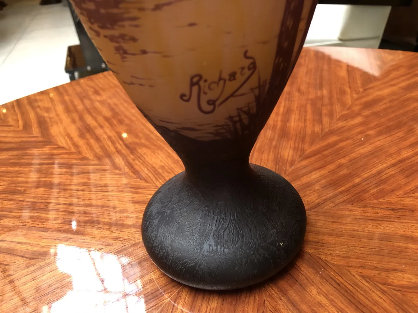 Antique glass signed by Richard, black base, light background.