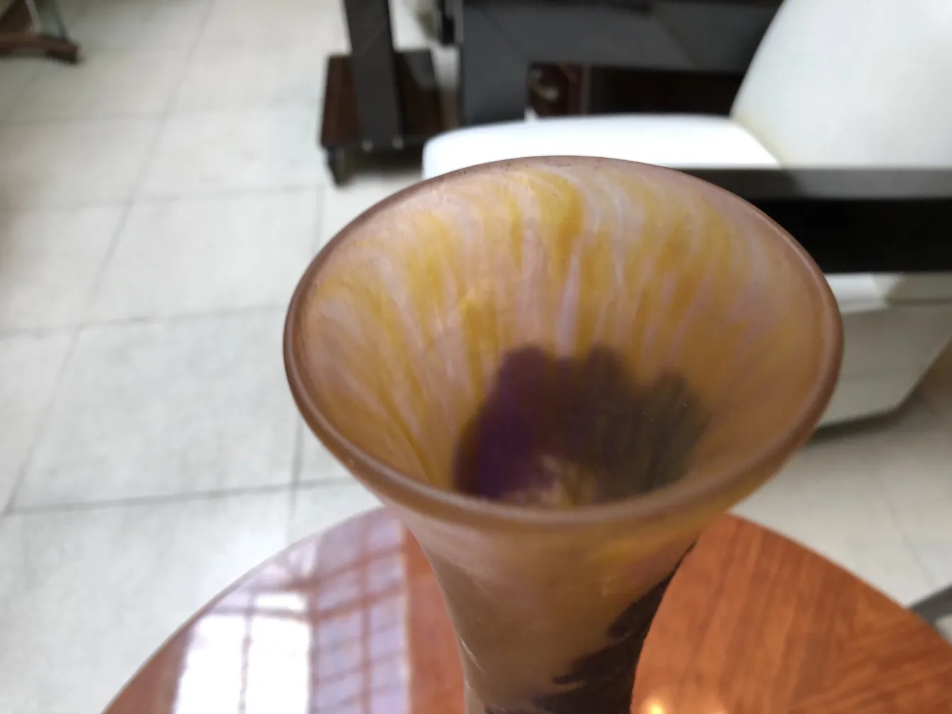 Vidro antigo assinado por Richard, com tons amarelos e roxos, em uma mesa de madeira