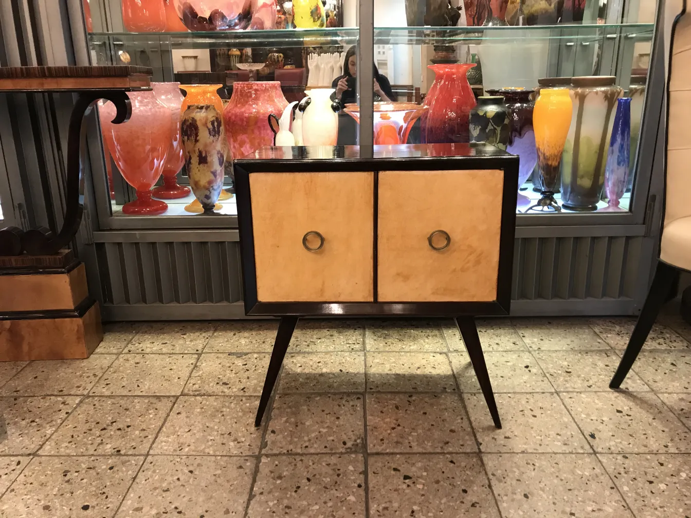 mesa de luz antigua con dos puertas y anillos dorados, en un ambiente de antigüedades