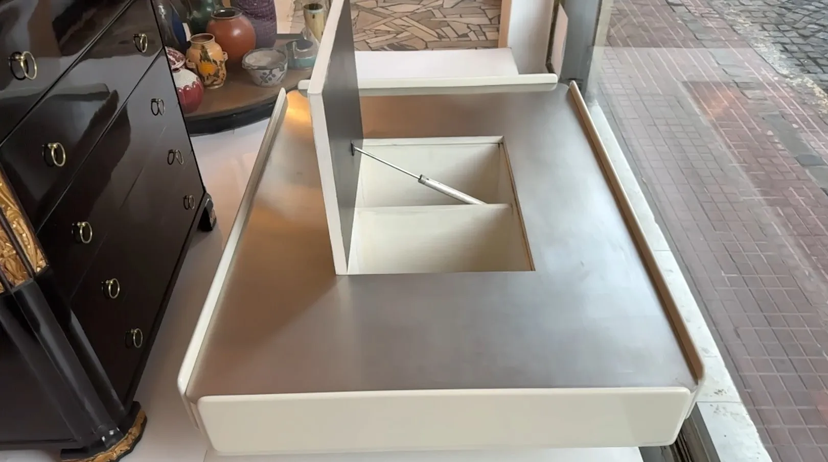 table basse ancienne avec un compartiment, fond chaleureux