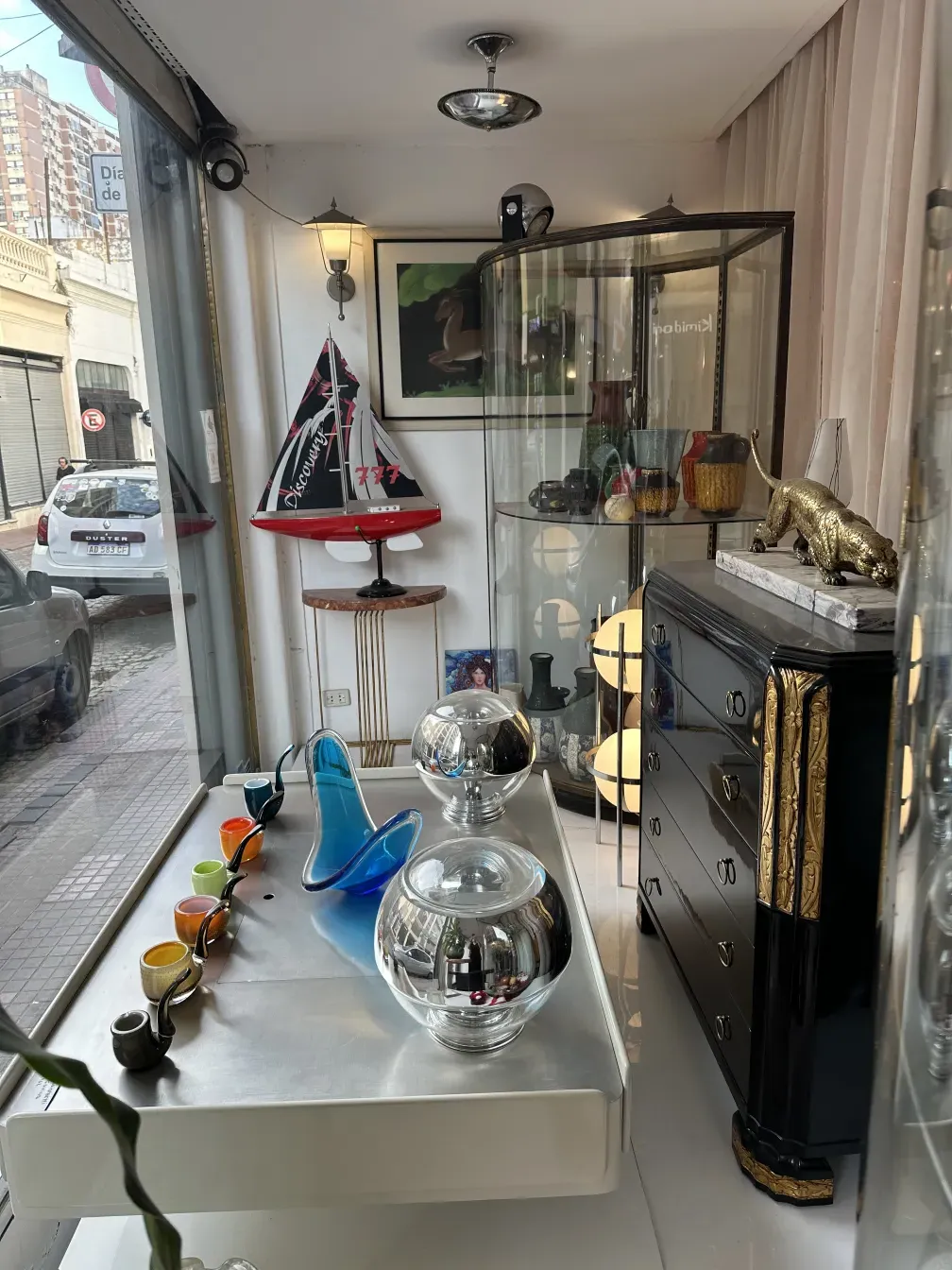 Mesa de centro antiga com decoração em um ambiente vintage, cercada por itens de antiguidade.