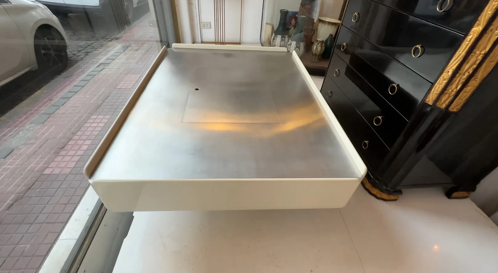 mesa ratona antigua con superficie lisa y bordes estilizados, en un ambiente acogedor