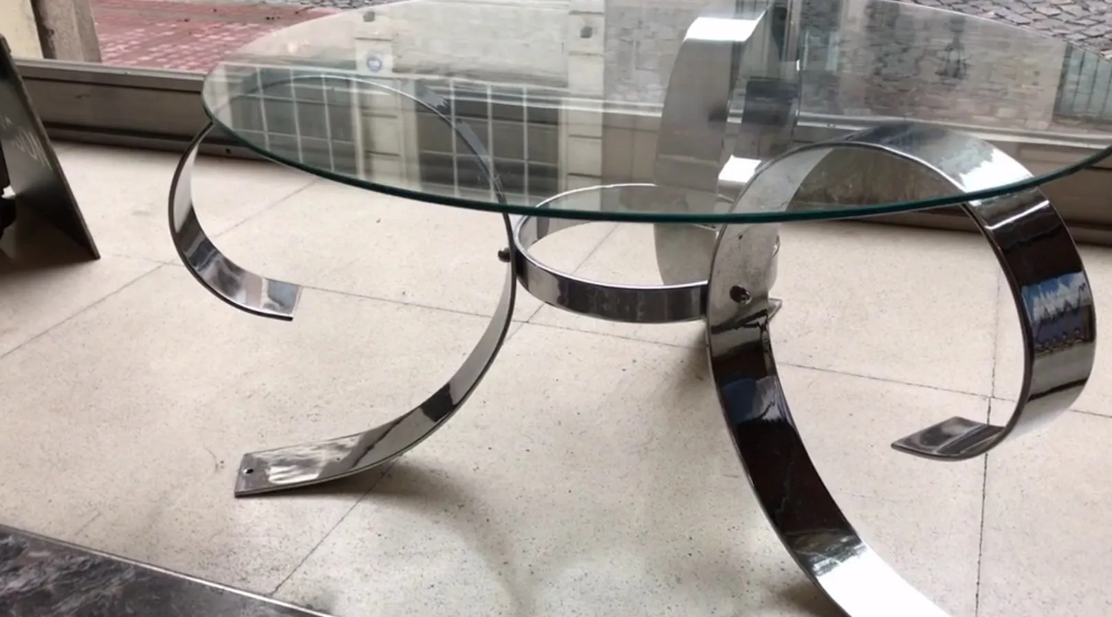 mesa ratona antigua con base curvada en un entorno moderno