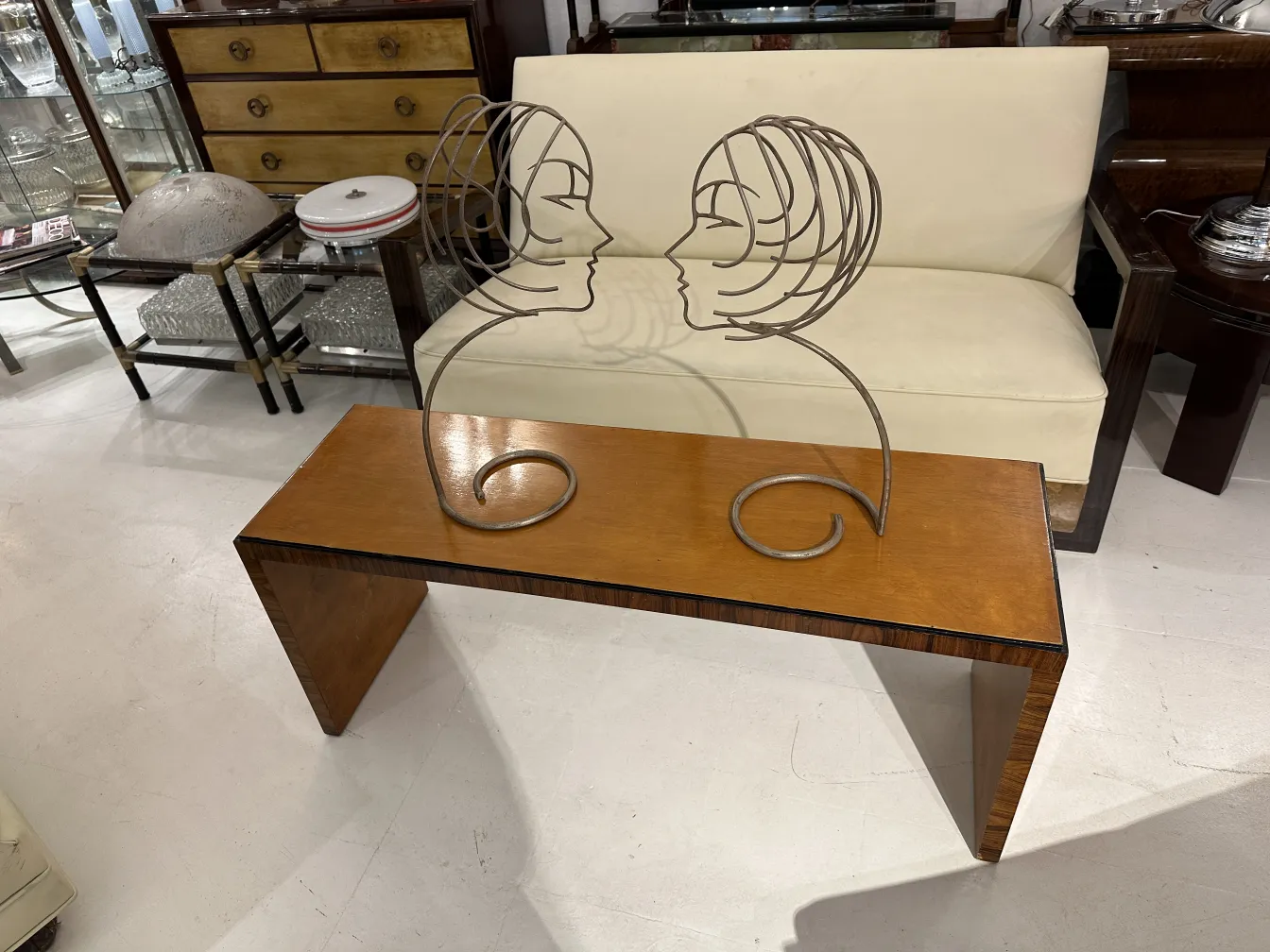 tavolino da caffè antico con figura decorativa di profilo, in un ambiente classico