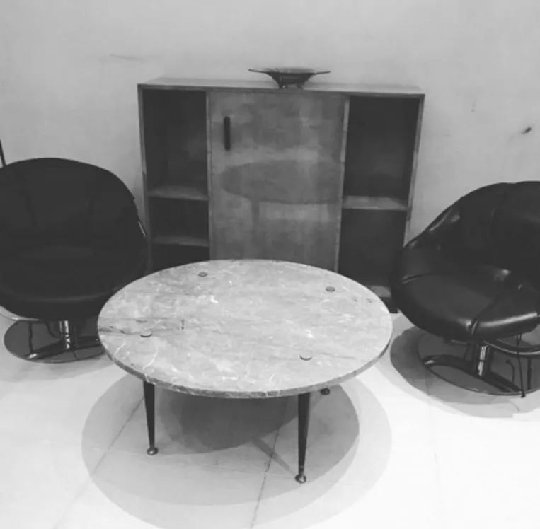 mesa de centro antiga redonda com cadeiras pretas